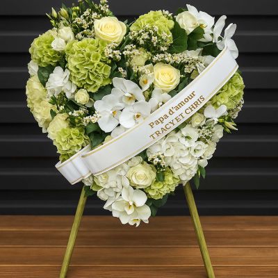 Grande gerbe funéraire élégante avec des roses blanches, des hortensias verts, des gerberas roses et un feuillage raffiné, conçue dans le Pays de Gex